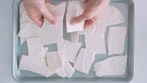 Breaking crisp meringue into small sheets for making Eton Mess.