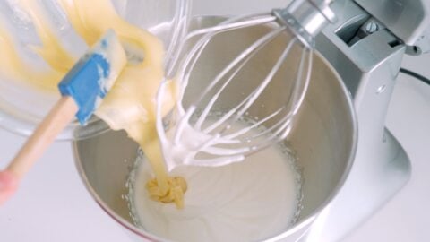 Adding white chocolate to whipped cream.