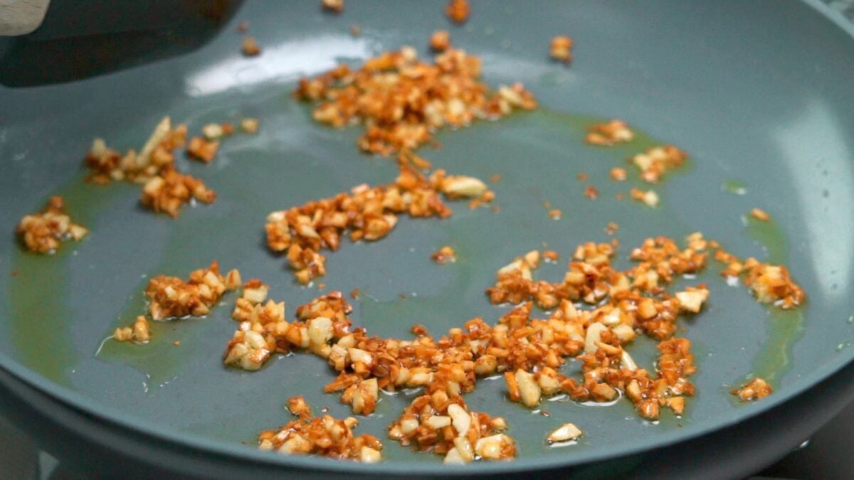 Frying garlic in oil until browned and crisp.