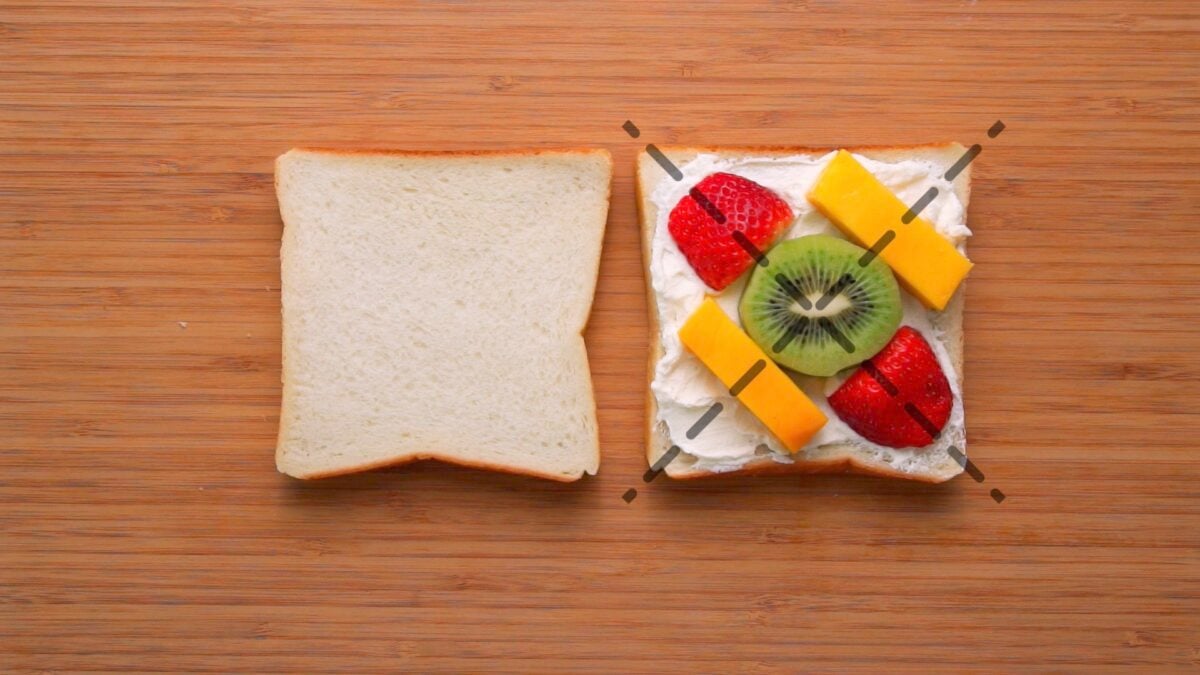 Lining up the fruit symmetrically along the cut lines for the fruit sandwich helps ensure you get an even cross section of fruit.