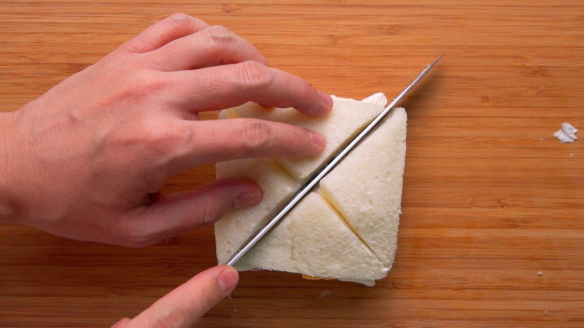 Slicing a fruit sandwich into quarters.