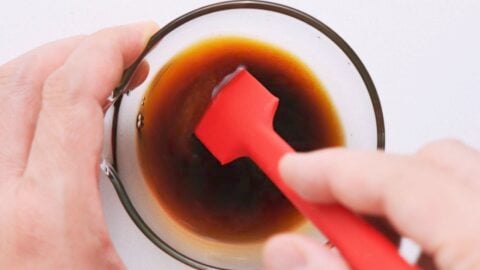 Mixing soy sauce, sake, sugar and salt in a glass bowl with a red spatula for Furikake.