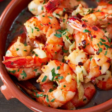 With plump juicy shrimp cooked with loads of garlic browned in olive oil, Gambas al Ajillo (garlic shrimp) is an easy Spanish tapa that comes together in about five minute. Be sure to have some bread handy to sop up the delicious briny oil.