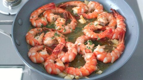 Spanish Garlic Shrimp (Gambas al Ajillo) in a frying pan garnished with parsley.