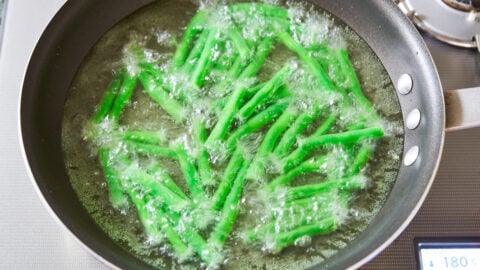 Oil blanching green beans before stir-frying them tenderizes them, while retaining their color.