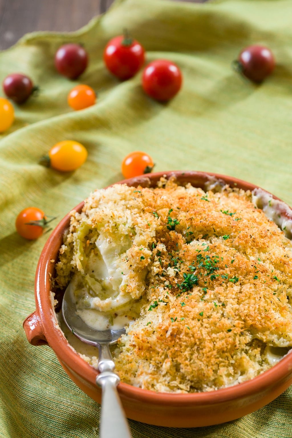 Tart tender green tomatoes are surrounded by a cheesy mornay sauce bubbling up from below in this Green Tomato Gratin. With a crisp panko and herb topping, this decadent side is addictively good.