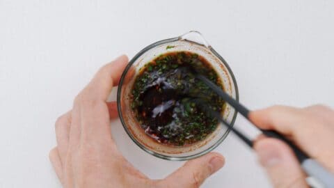 Whisking chili oil into a spicy potsticker dipping sauce for gyoza.