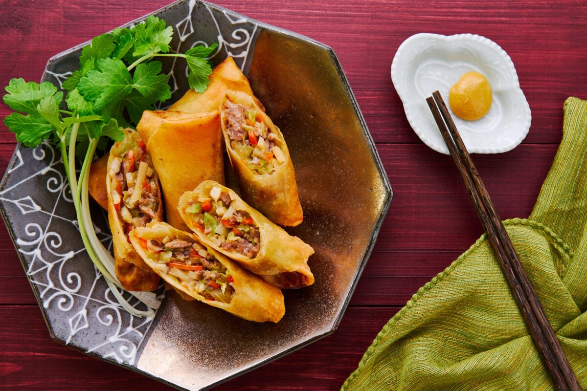 A plate of Harumaki (Japanese Spring Rolls) with celery sprouts and hot mustard.