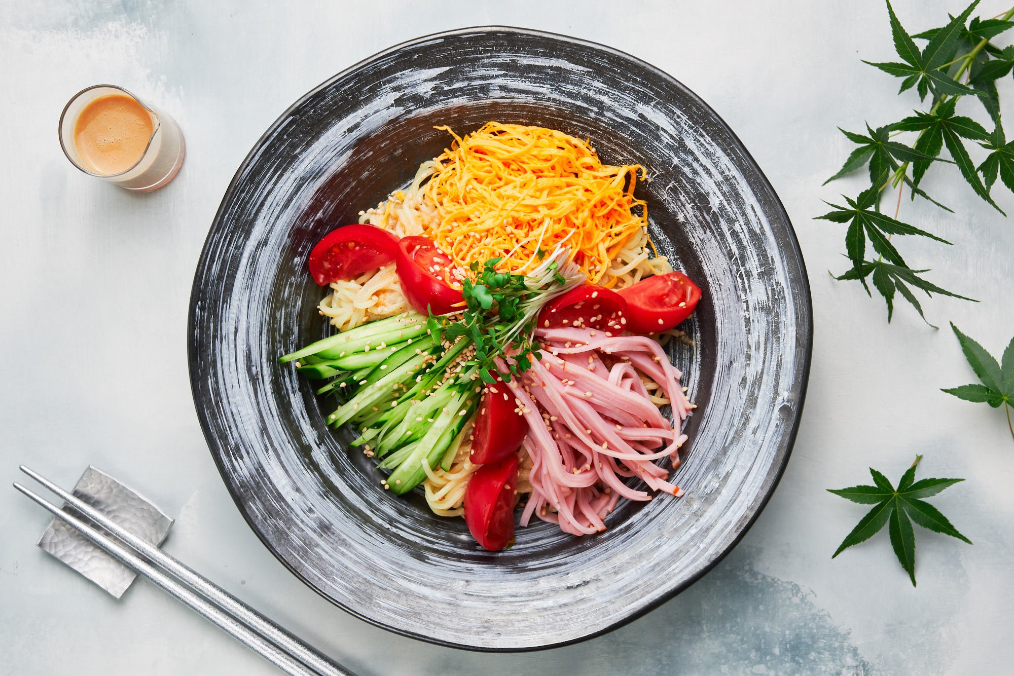 Topped with sweet tomatoes, crisp cucumbers, savory ham, and golden threads of egg, this easy ramen salad (hiyashi chuka) is the perfect summer meal.