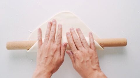 Rolling udon dough onto rolling pin.