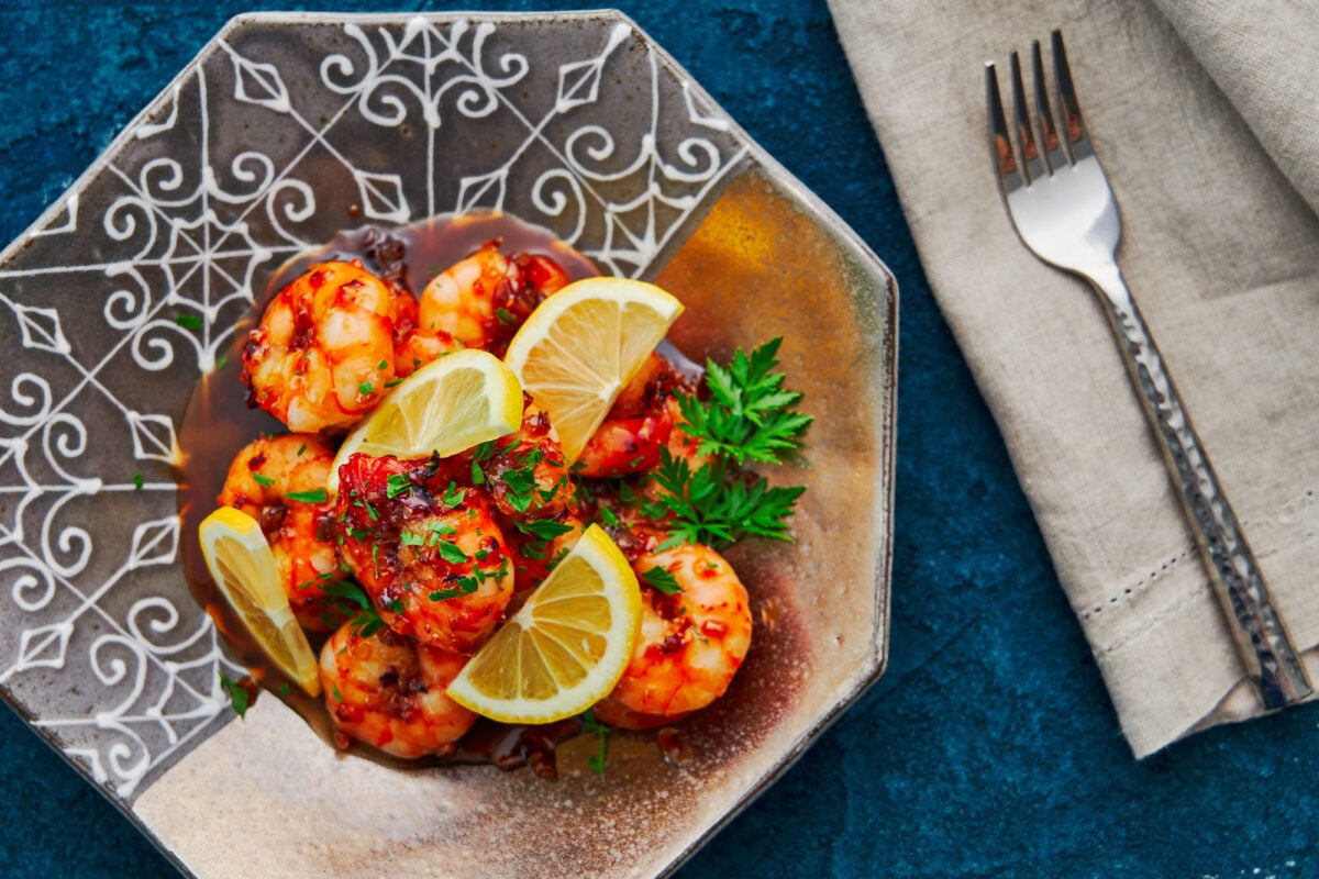 Shrimp with honey garlic sauce garnished with parsley and lemons.