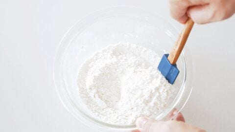 Mixing flour and salt in a glass bowl for making Hungarian Dumplings.