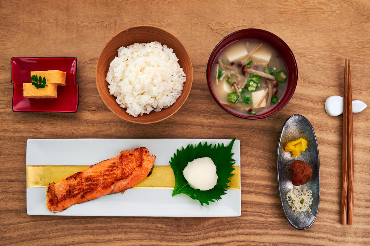 A traditional Japanese breakfast, including grilled salted salmon, tamagoyaki, rice, miso soup and pickles.