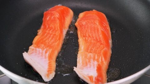 Shiozake salmon being pan-fried.