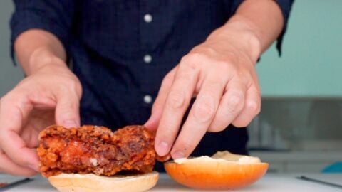 Adding a piece of Japanese fried chicken to a bun.