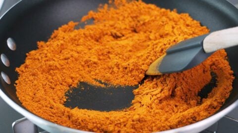 Toasting curry powder in a frying pan.