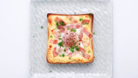 Japanese egg toast topped with bacon and scallions.