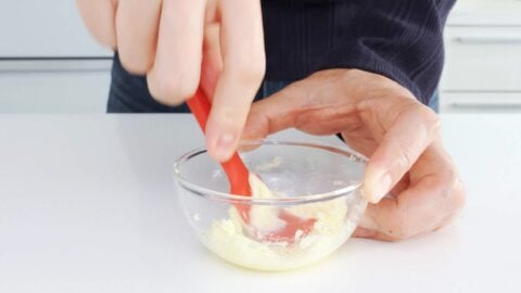 Mashing butter and grated garlic together.