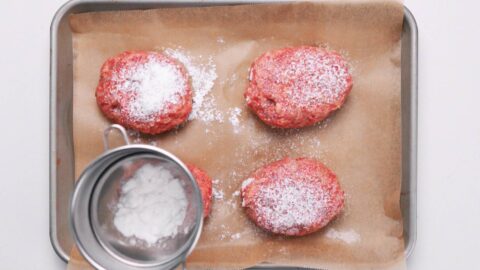 Dusting Hamburg Steak patties with potato starch.