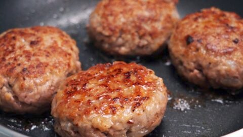 Browned Japanese hamburger steaks in a frying pan.