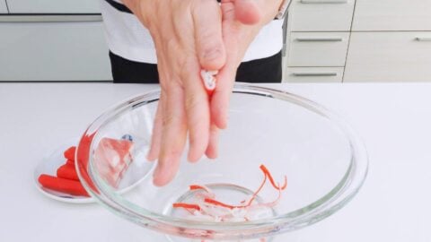 Shredding crab sticks by rolling between hands.