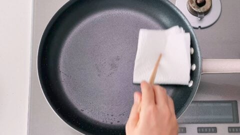 Wiping out the oil from the pan before glazing the pork.