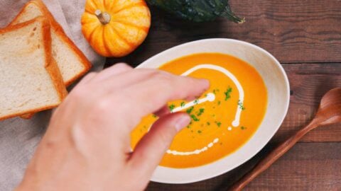 Garnishing kabocha squash soup with parsley and cream.