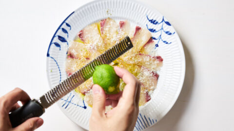 Kanpachi carpaccio being finished with lime zest.