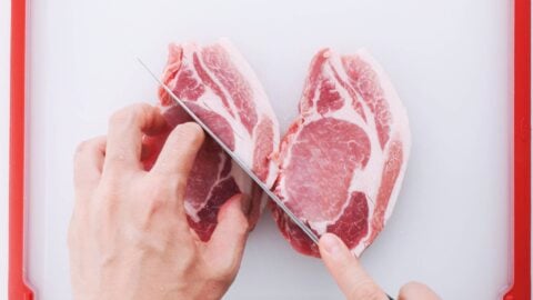 Cutting slits into pork chops for making tonkatsu