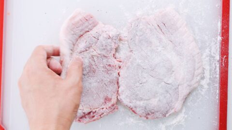 Pork cutlets dusted with flour for making katsu.