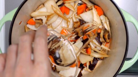 Sake being added to sautéed vegetables to make Kenchinjiru.