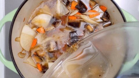 Adding shiitake dashi to vegan Japanese soup.