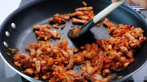 Stir-frying pork belly with kimchi.