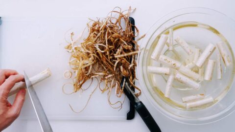 Peeled burdock in a bowl of water.