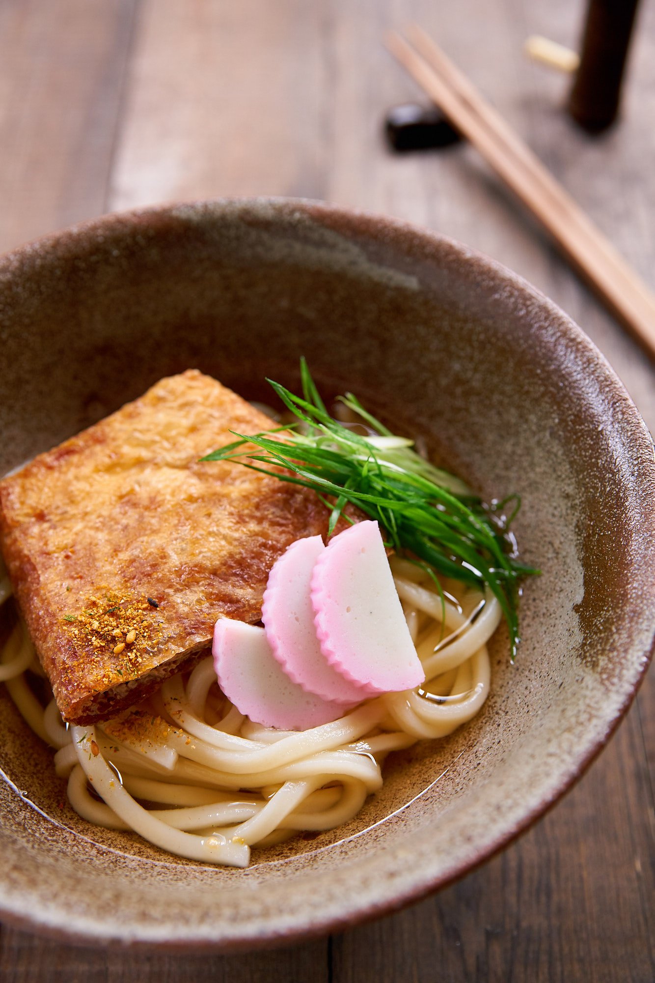 A classic Japanese noodle soup, Kitsune Udon features thick udon noodles in a light dashi broth, with a savory sweet slice of fried tofu on top.