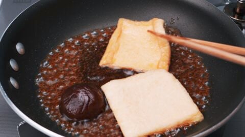 Making Inari Agé with fried tofu, soy sauce, sugar and sake.