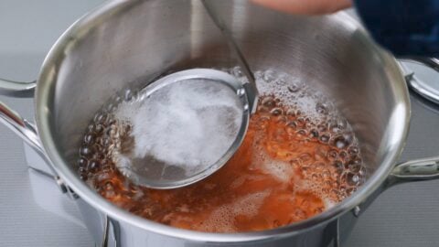 Skimming vegan udon broth.