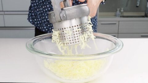 Mashing potatoes using a ricer.