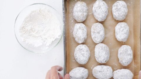 Dusting croquette patties with flour.