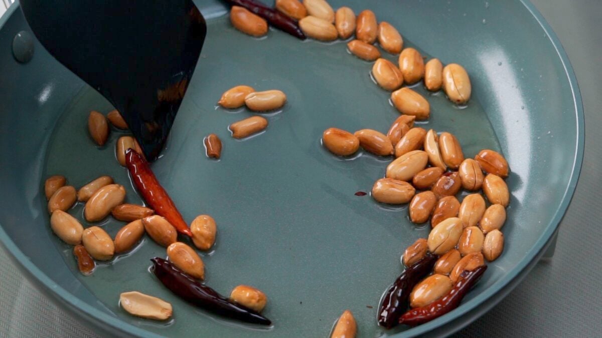 Oil-roasting peanuts and chili peppers for Kung Pao Tofu.