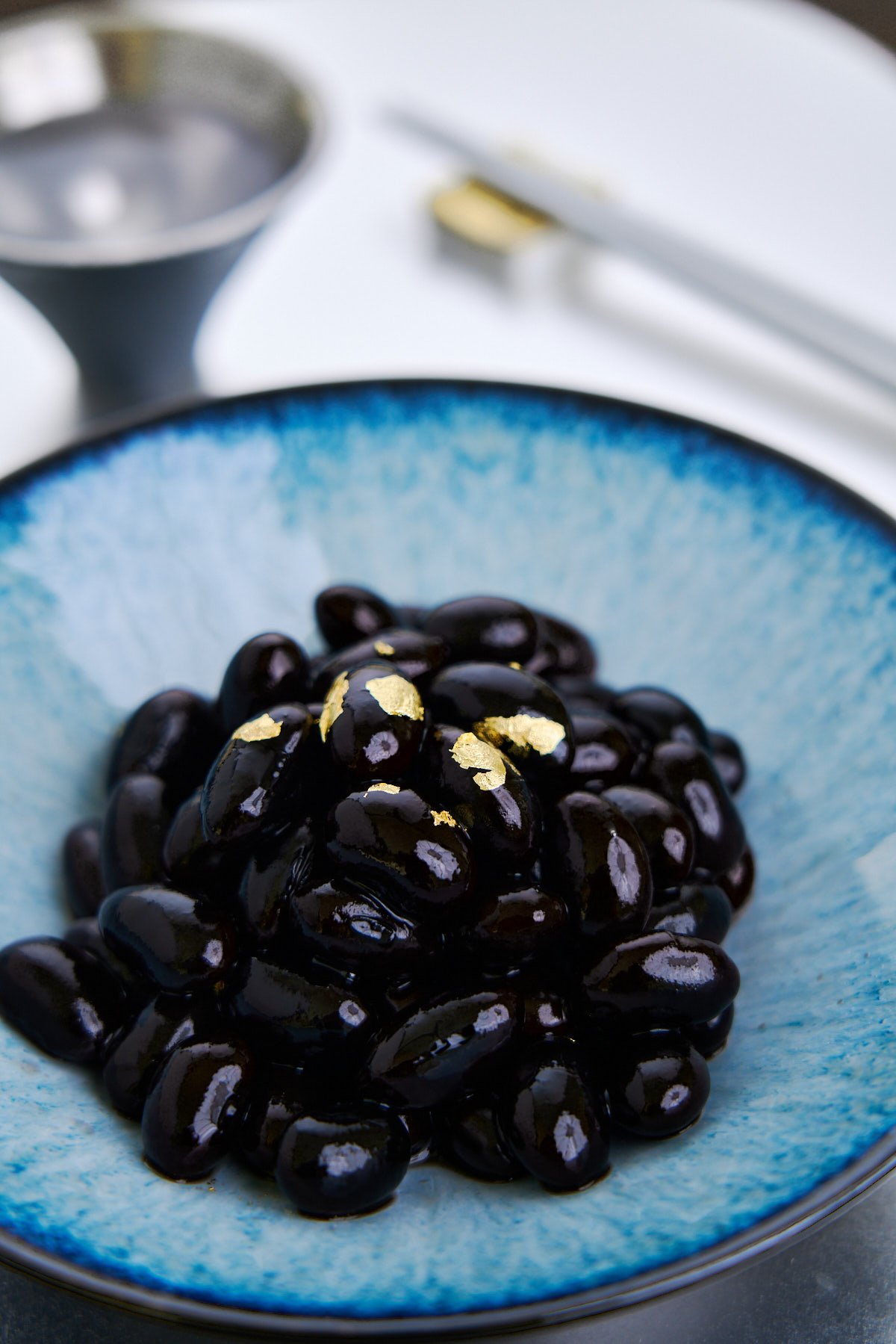 Kuromame are black soybeans cooked in a sweet and savory syrup until the midnight black skins melt away in your mouth to reveal the velvety beans in the center. It's a staple of Osechi Ryori or Japanese New Years' cuisine.