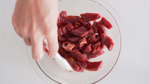 Marinating beef tenderloin in sauce for making Lomo Saltado