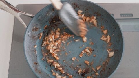 Sautéing garlic and ginger in a frying pan for making Lomo Saltado