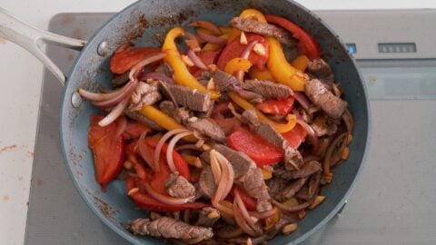 Stir-fried Lomo Saltado in a frying pan.