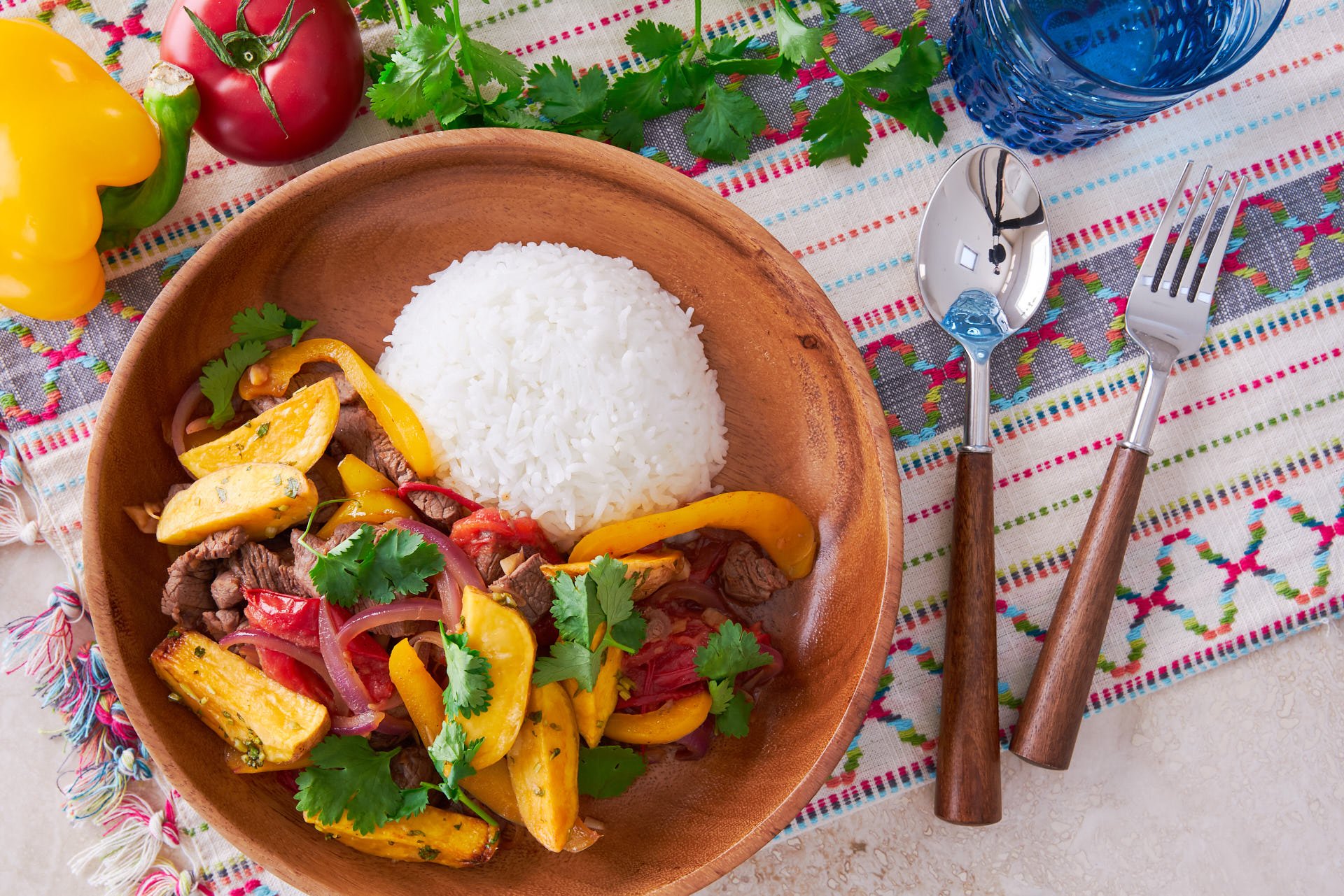 With tender beef marinated in soy sauce and pisco, Lomo Saltado is a delicious Peruvian-Chinese stir-fry that's loaded with potatoes, onions, tomatoes, and garlic.