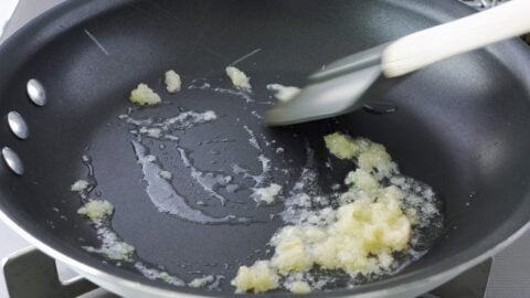 Stir-frying ginger and garlic in a frying pan.