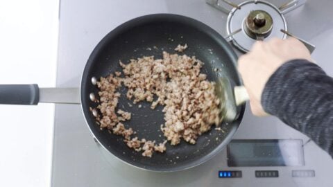 Stir-frying ground pork for mapo eggplant.