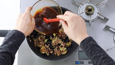 Adding mapo sauce to meat and eggplant mixture.