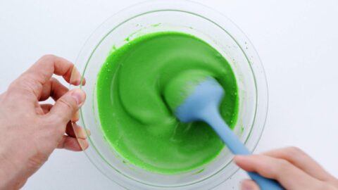 Stirring together matcha ice cream base with spatula.