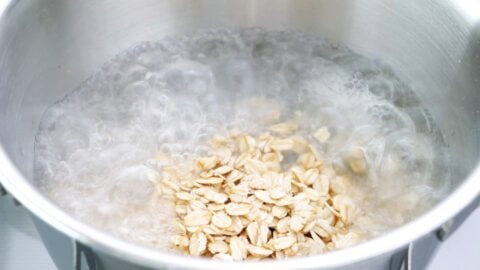 Rolled oats added to a pot of boiling water.